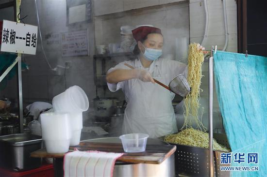 4月22日，武漢市糧道街的家陽“趙師傅”天天紅油熱干面店廚師在制作熱干面。新華社記者 沈伯韓 攝