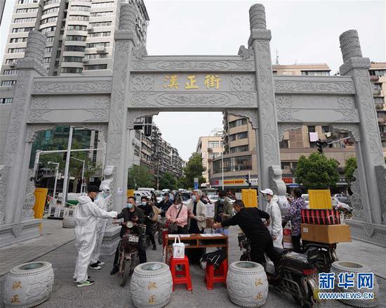  4月16日，進出武漢漢正街步行街的人員在掃描健康碼。新華社記者 王毓國 攝