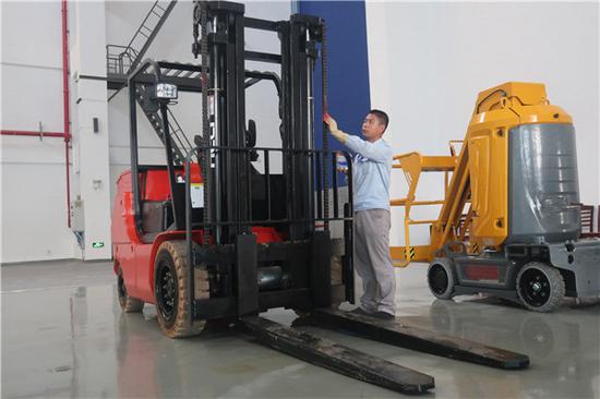 (史祥健進行叉車維護)